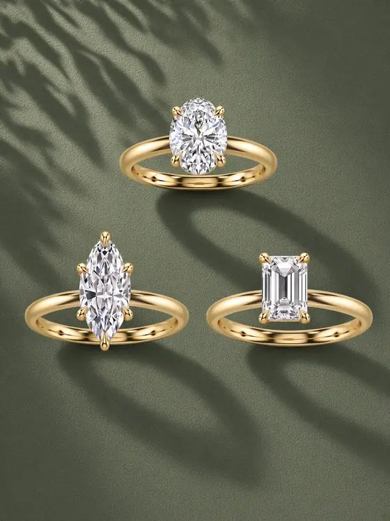 Three solitaire engagement rings with plain yellow gold bands in oval, marquise and emerald cuts